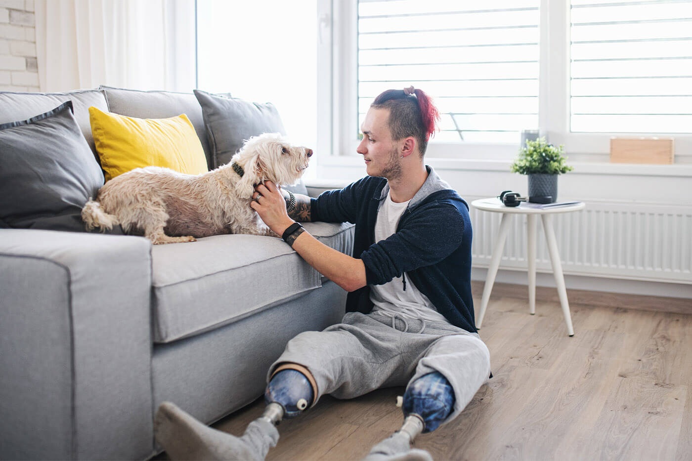 Man With Prosthetic Limbs In Livingroom With Dog